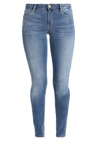 Skinny jeans in light blue denim, featuring a faded finish, classic five-pocket design, and button closure at the waist.