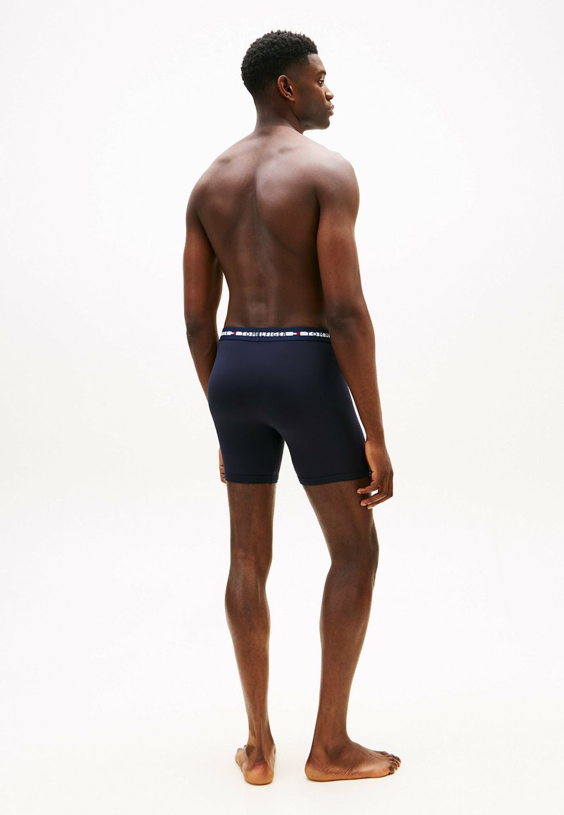 Shorts de bain bleu marine avec une ceinture à motifs. Fabriqués en matériau extensible, présentant un design ajusté et une longueur jusqu'à mi-cuisse.