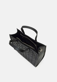 Svart tote-väska med chevronmönster, syntetmaterial, dubbla handtag och inre fack. Fick med dragkedja för säker förvaring.