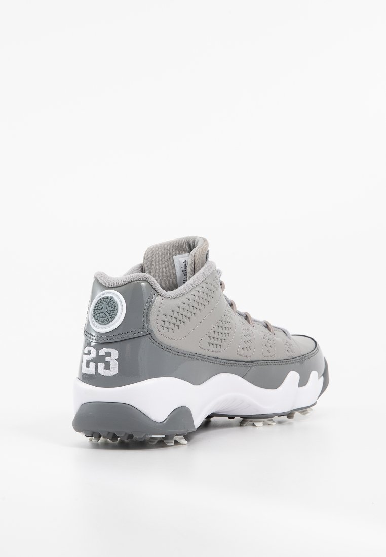 Zapatilla gris con diseño de caña alta, parte superior texturizada, acentos reflectantes y suela blanca. Presenta el número "23" en el talón y paneles de malla.