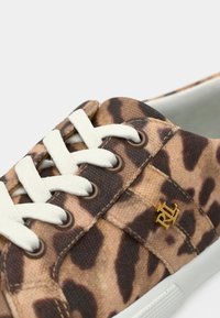 Αθλητικό παπούτσι με ύφασμα λεοπάρ καφέ και μαύρου χρώματος, λευκά κορδόνια, μεταλλικά οφθαλμίσκους και μικρό χρυσό λογότυπο "RL" στο πλάι.