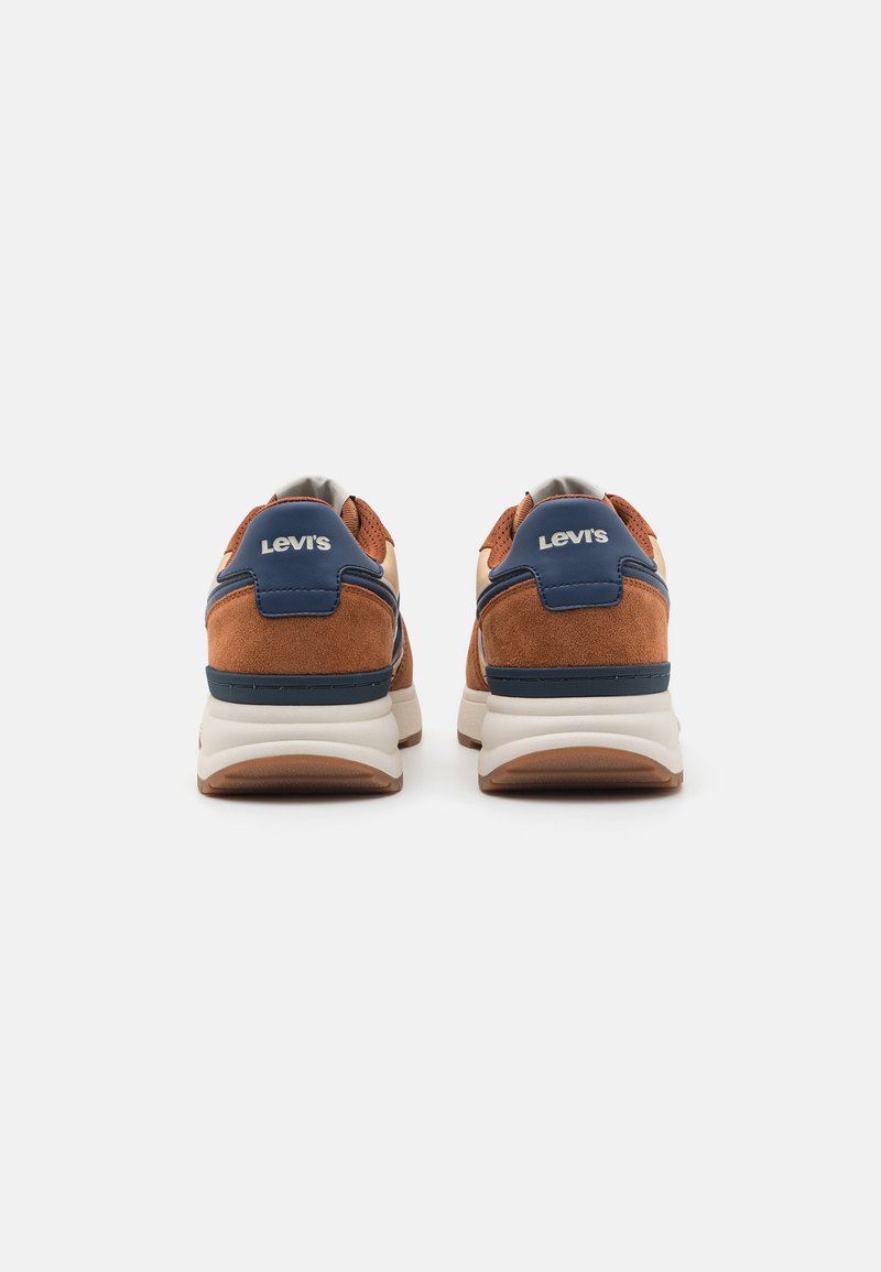 Brune ruskindssneakers med marineblå detaljer, hvid mellemsål og tan gummisål. Har "Levi's" logo på hælen.