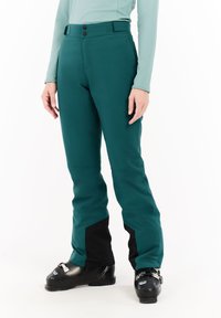 Teal ski broek met zwarte accenten, gemaakt van een waterdicht materiaal. Ze hebben een slim fit, een verstelbare taille en versterkte onderbenen.