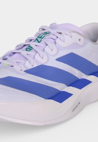 Chaussure de sport blanche et bleue à lacets avec semelle "Lightstrike Pro", présentant trois bandes bleues sur le côté.