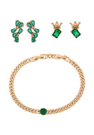 Złota bransoletka z zielonym, okrągłym kamieniem, kolczyki w kształcie zielonych kropel w klastrze oraz złote kolczyki w kształcie korony z zielonymi kwadratowymi kamieniami i małymi białymi kamieniami.