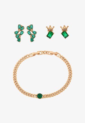 Złota bransoletka z zielonym, okrągłym kamieniem, kolczyki w kształcie zielonych kropel w klastrze oraz złote kolczyki w kształcie korony z zielonymi kwadratowymi kamieniami i małymi białymi kamieniami.