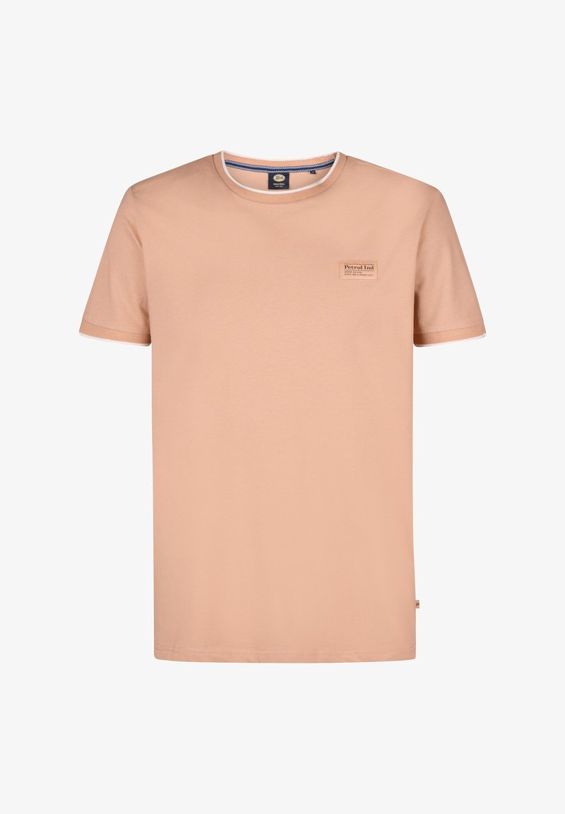 T-shirt en coton couleur pêche, avec un col rond, des manches courtes et une petite étiquette de marque sur la poitrine. Présente une bordure blanche contrastante.