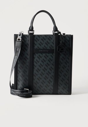 Sac cabas noir avec motif monogramme, double poignée, bandoulière réglable et pendentif décoratif, signé "Karl Lagerfeld" sur la face avant.