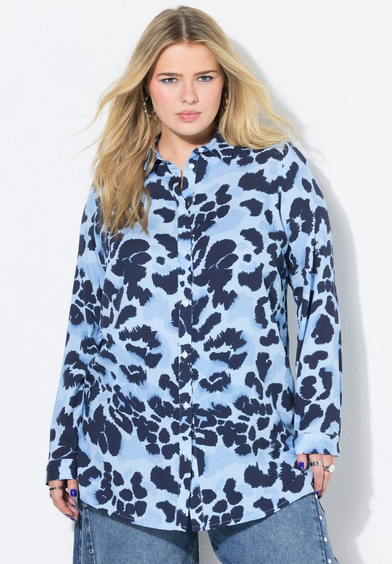 Lichtblauw overhemd met knoopsluiting, voorzien van een marineblauw luipaardprintpatroon. Lange mouwen met manchetten en een klassieke kraag.