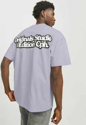 Lavendel t-shirt med korte ærmer, afslappet pasform, med et stort sort-hvidt grafisk tekstmotiv på ryggen. Materiale i bomuldsblanding.