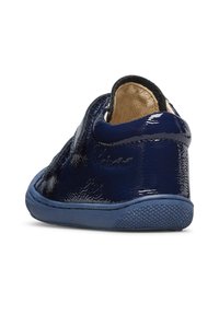 Zapato de charol azul marino con una superficie texturizada, parte trasera redondeada y suela de goma azul. Presenta acentos negros en la zona del tobillo.