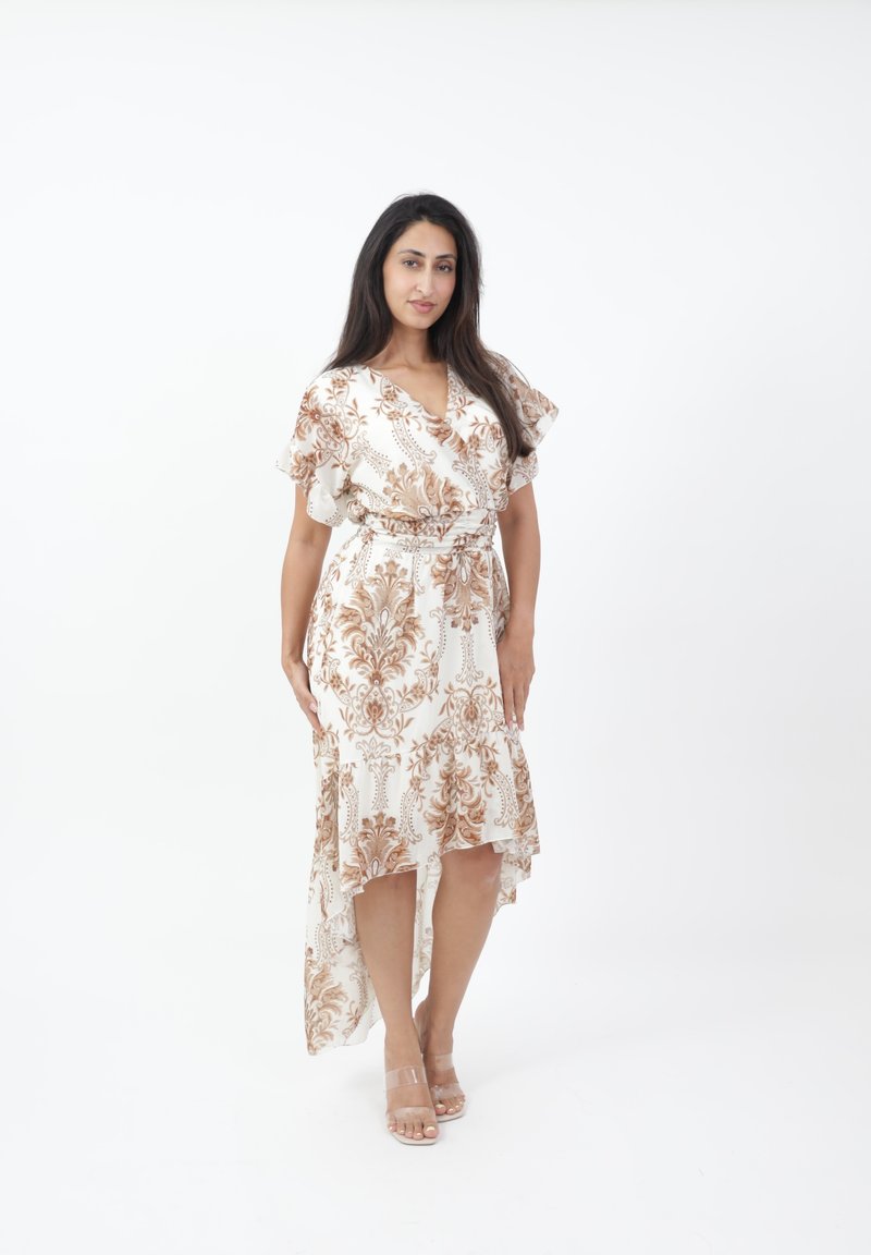 Robe blanche avec un motif floral marron, manches courtes volantes, taille cintrée et ourlet asymétrique. Tissu lisse et sandales transparentes.