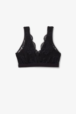 Czarny koronkowy biustonosz z kwiatowymi wzorami, o głębokim dekolcie w kształcie litery V, szerokich ramiączkach oraz miękkiej elastycznej taśmie dla wsparcia.
