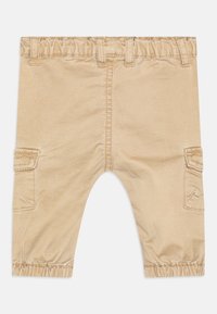 Tan cargo broek met een elastische tailleband, zijzakken en gathered cuffs. Glad, duurzaam materiaal met een nette afwerking.