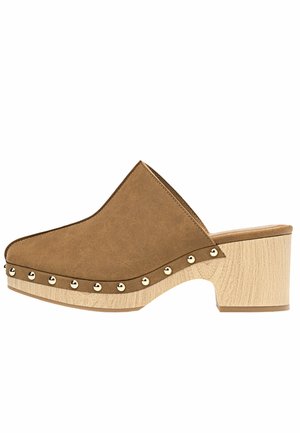 Sabots synthétiques marron à enfilage avec une silhouette courbée, ornés d'accents en studs dorés le long de la semelle extérieure et d'un talon chunky imitant le bois.