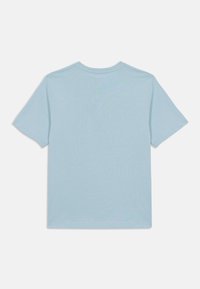 T-shirt bleu clair à manches courtes, fabriqué en tissu doux avec un col rond. Design simple, texture lisse, sans motifs ni accents visibles.