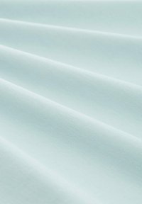 Svetlomodrá látka s hladkou textúrou, obsahujúca jemné záhyby a mierny lesk. Materiál sa zdá byť jemný a ľahký.