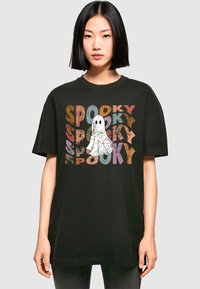Schwarzes Baumwoll-T-Shirt mit buntem "spooky"-Text und einem Gespenst-Graphic. Übergrößenpassform mit kurzen Ärmeln und Rundhalsausschnitt.