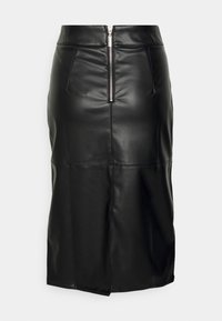 Svart imitation läder midi kjol med framfinnande silverblixtlås och sömdetaljer på en enkel ljus bakgrund.