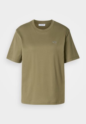 T-shirt en coton vert olive avec des manches courtes, un col ras du cou et un petit logo de crocodile brodé sur la poitrine gauche.