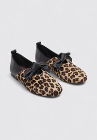 Zapatos slip-on con estampado de leopardo, detalles de cuero negro y un doble lazo en la parte delantera, con puntera redonda y suela plana.