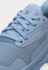 Ανοιχτό μπλε αθλητικό παπούτσι με υφασμάτινο επάνω μέρος με υφή, παχύ κορδόνια δεμένα σταυρωτά, επενδυμένη γλώσσα και παχύ μαξιλαρωμένο πέλμα.