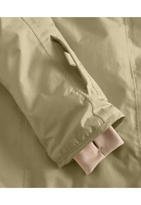 Beige vízhatlan dzseki ujja rugalmas kötött részletű mandzsettával, cipzáras zsebbel és sima külső textúrával.