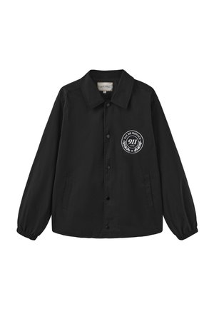 Czarna kurtka na guziki z kołnierzem, elastycznymi mankietami, bocznymi kieszeniami oraz białym okrągłym logo "Pas de Monaco 911 Club" na lewej piersi.