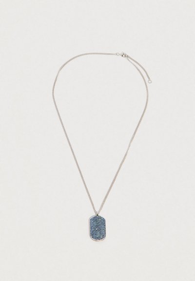 Stříbrný náhrdelník s obdélníkovým přívěskem pokrytým malými modrými a černými krystaly na jednobílém pozadí.