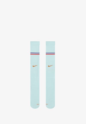 Chaussettes de sport Nike bleu clair avec des rayures rouges, blanches et bleues près du haut et un logo Nike swoosh orange sur chaque chaussette.