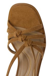 Sandale à talon haut en daim marron avec plusieurs brides tressées et un bout carré. Présente une semelle intérieure lisse de couleur claire avec des accents dorés.
