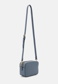 Sac bandoulière rectangulaire en matériau synthétique bleu, avec une fermeture éclair dorée et une sangle réglable. Texture lisse, design minimaliste.