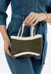 Lille olivengrøn faux suede taske med hvid fleece kant og dobbelt håndtag. Guld logo detaljer foran, rektangulær form.