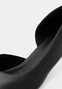 Μαύρο δερμάτινο παπούτσι με υφή, επιφάνεια με τύπωμα κροκοδείλου, στρογγυλεμένη μύτη και λεία εσωτερική επένδυση. Απλή, κομψή γραμμή.