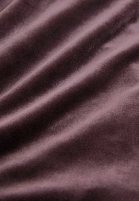 Fluwelen stof in diep paars, met een gladde textuur, zachte, subtiele glans en zachte golfpatronen.