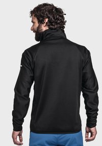 Schwarzer Fleece-Pullover mit hohem Kragen, langen Ärmeln und glatter Textur. Verfügt über Raglanärmel und seitliche Nahtakzente.