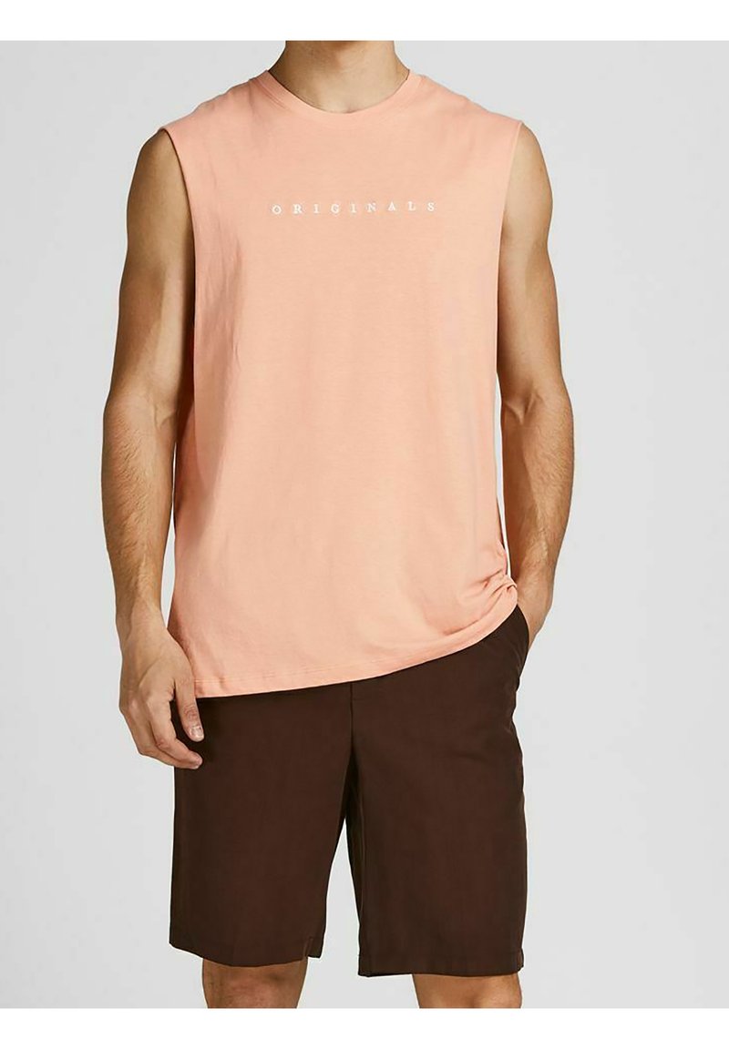 T-shirt sans manches de couleur pêche clair avec le texte "ORIGINALS" en blanc, associé à un short marron foncé. Matière en coton, coupe décontractée, design minimal.