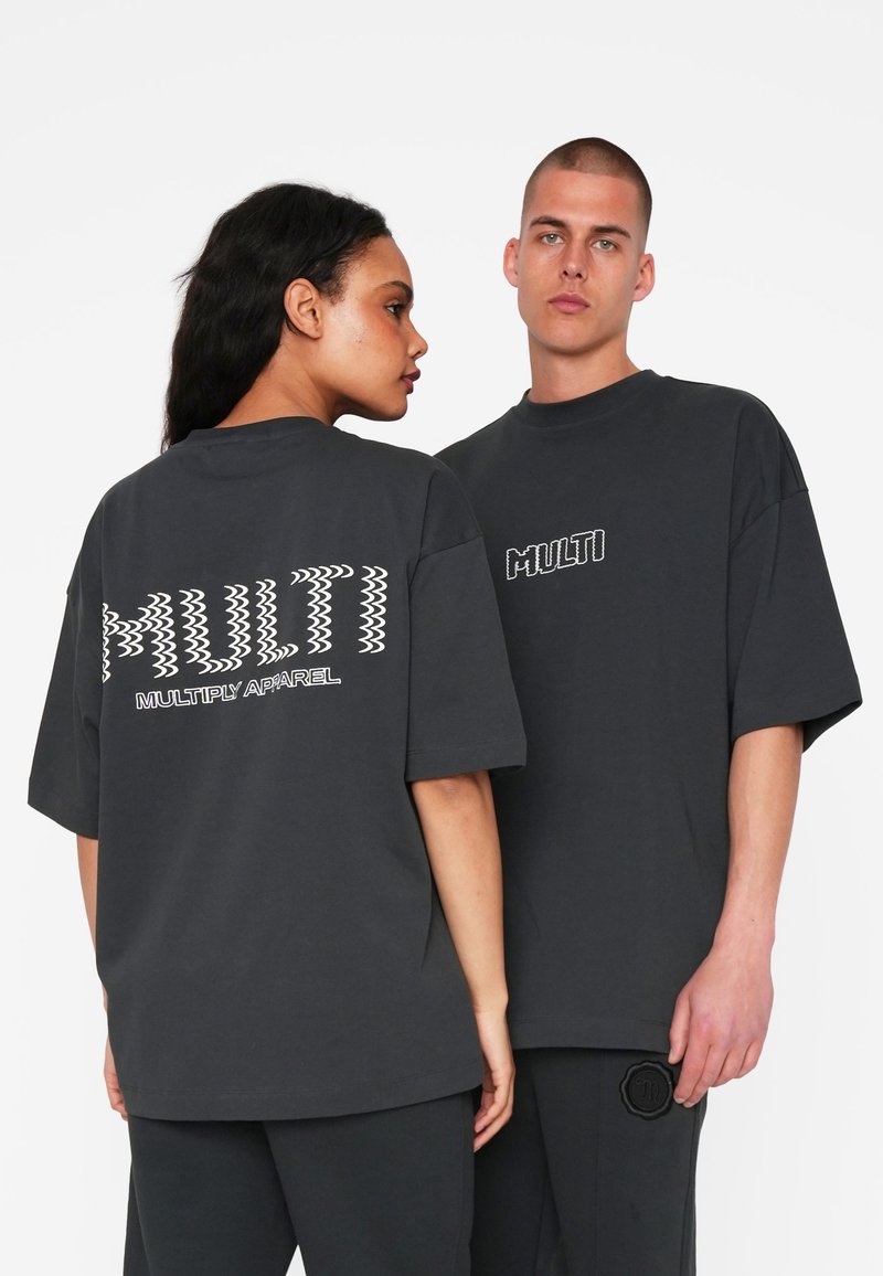 Overdimensionerede sorte bomulds T-shirts har fed hvid "MULTI" tekst på både ryggen og forsiden, med et struktureret grafisk design.