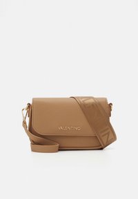 Lys brun lærveske med teksturert overflate, magnetisk klafflukking og et mønstret reim med "VALENTINO" i fet skrift.