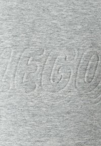 Sivá bavlnená mikina s textúrovaným, embosovaným logom na prednej strane. Mäkká látka a ležérny dizajn s hladkým povrchom.