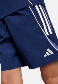 Marineblaue Sportshorts aus glattem Material mit drei weißen Streifen an der Seite und einem gestickten Logo am Saum.