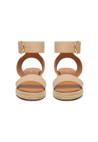 Béžové platformové šľapky so širokými remienkami, prackou na členku a podrážkou z tkaného jutového materiálu. Hladký kožený zvršok s zaoblenými výrezmi na bokoch.