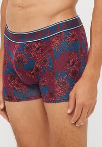 Herren-Boxershorts in navyblau mit rotem Blumenmuster. Elastischer Bund mit Branding. Aus dehnbarem Stoff für Komfort und Passform hergestellt.