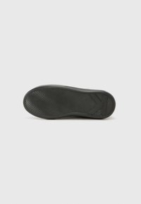 Semelle de chaussure en caoutchouc noir avec un motif de diamant ondulé et de légères accents surélevés. Texture lisse avec un design minimaliste et sans marque visible.
