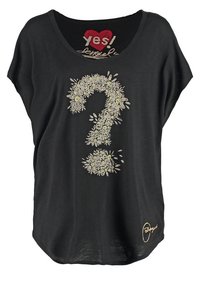 Volné černé tričko s širokým výstřihem, na kterém je květinový design otazníku ve žluté a bílé barvě. Text říká "ano!" v červeném srdci.