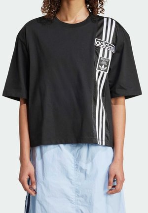 Černé bavlněné tričko s krátkým střihem, bílým logem Adidas a třemi bílými svislými pruhy na jedné straně. Obsahuje detail s texturovaným panelem.