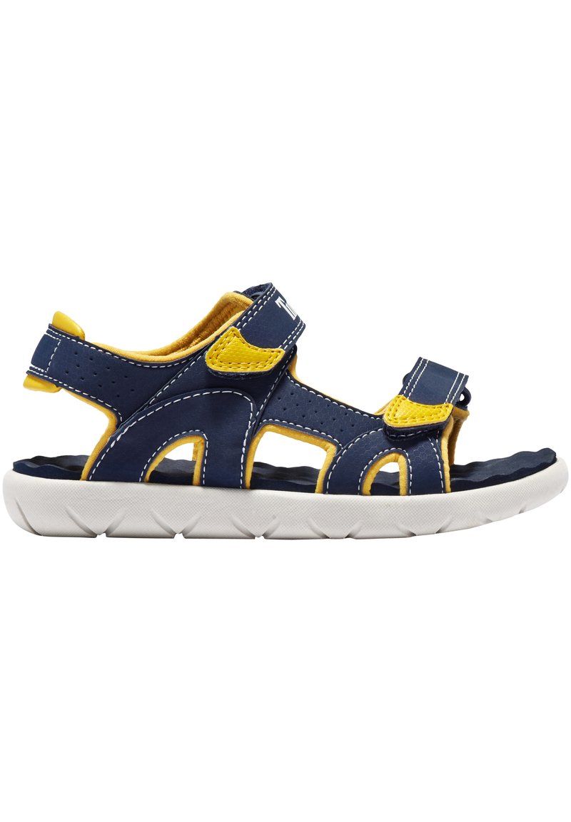 Navy blue sandaalit, joissa on keltaisia tehosteita, valmistettu synteettisestä materiaalista. Varustettu säädettävillä tarranauhakiinnityksillä ja valkoisella kumipohjalla, jossa on teksturoitu pito.