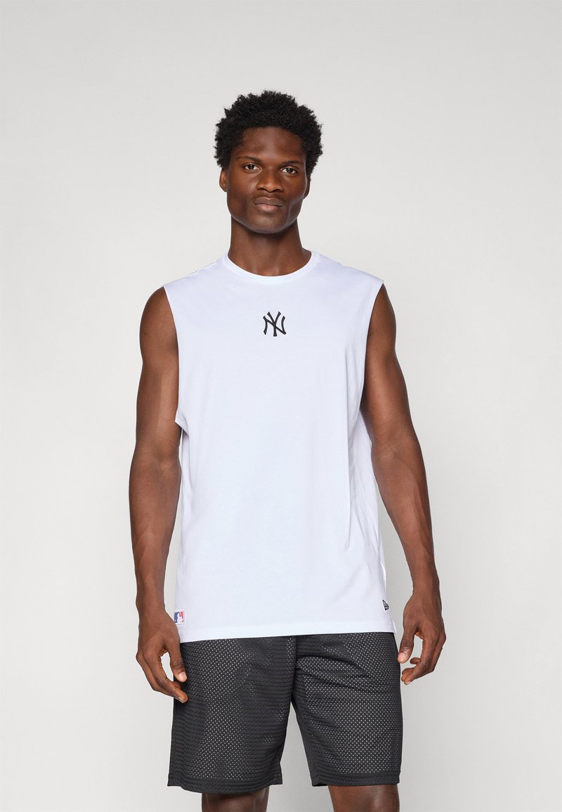 T-shirt sans manches blanche avec le logo NY noir sur la poitrine ; associée à un short en mesh noir, mettant en valeur une coupe athlétique et une texture respirante.