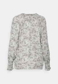 Langærmet bluse med et tekstureret, abstrakt mønster i nuancer af hvid og grå. Har elastiske manchetter og en samlet halsudskæring.