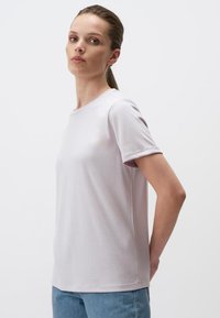 T-shirt grigio chiaro a maniche corte in cotone morbido, con scollatura a girocollo e vestibilità comoda, mostrato di lato.